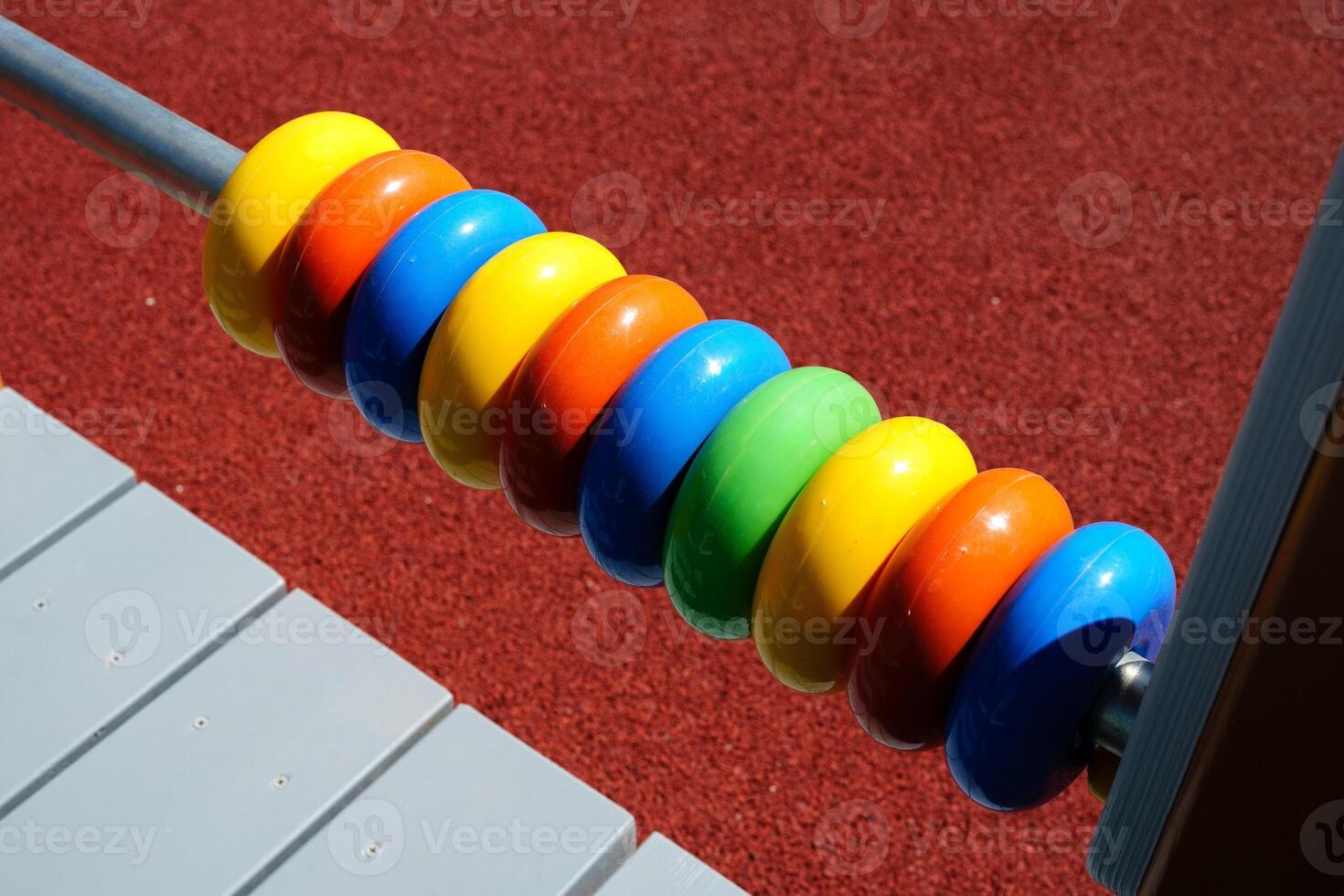 Colorful wooden counting beads shine in sunlight on a playground equipment during daytime outdoor playtime photo