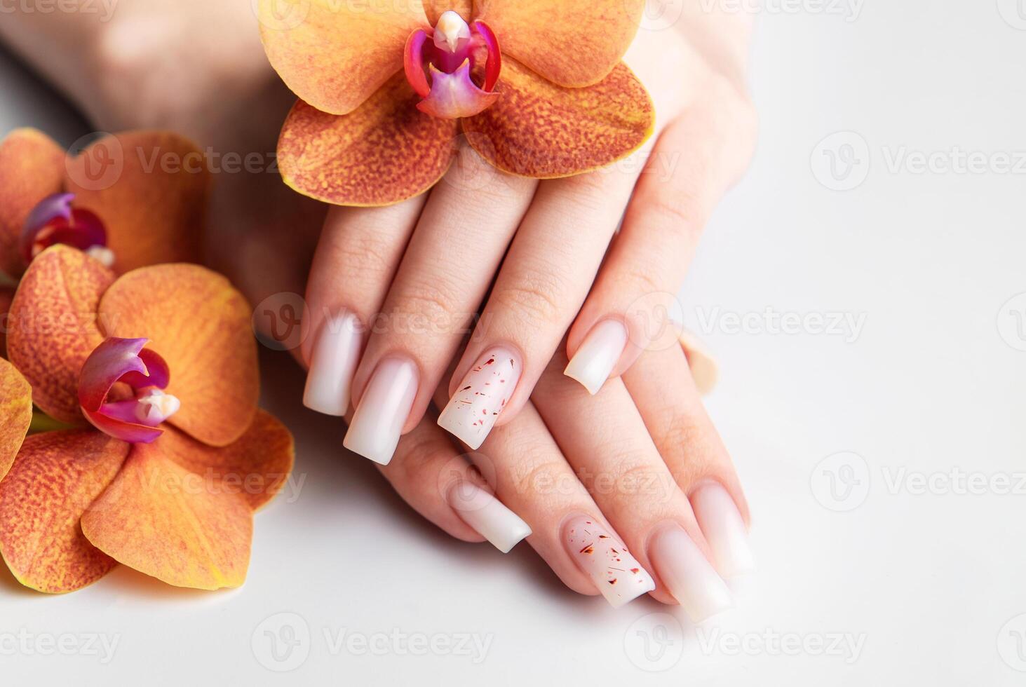 Woman showing stylish white nails with orchid photo