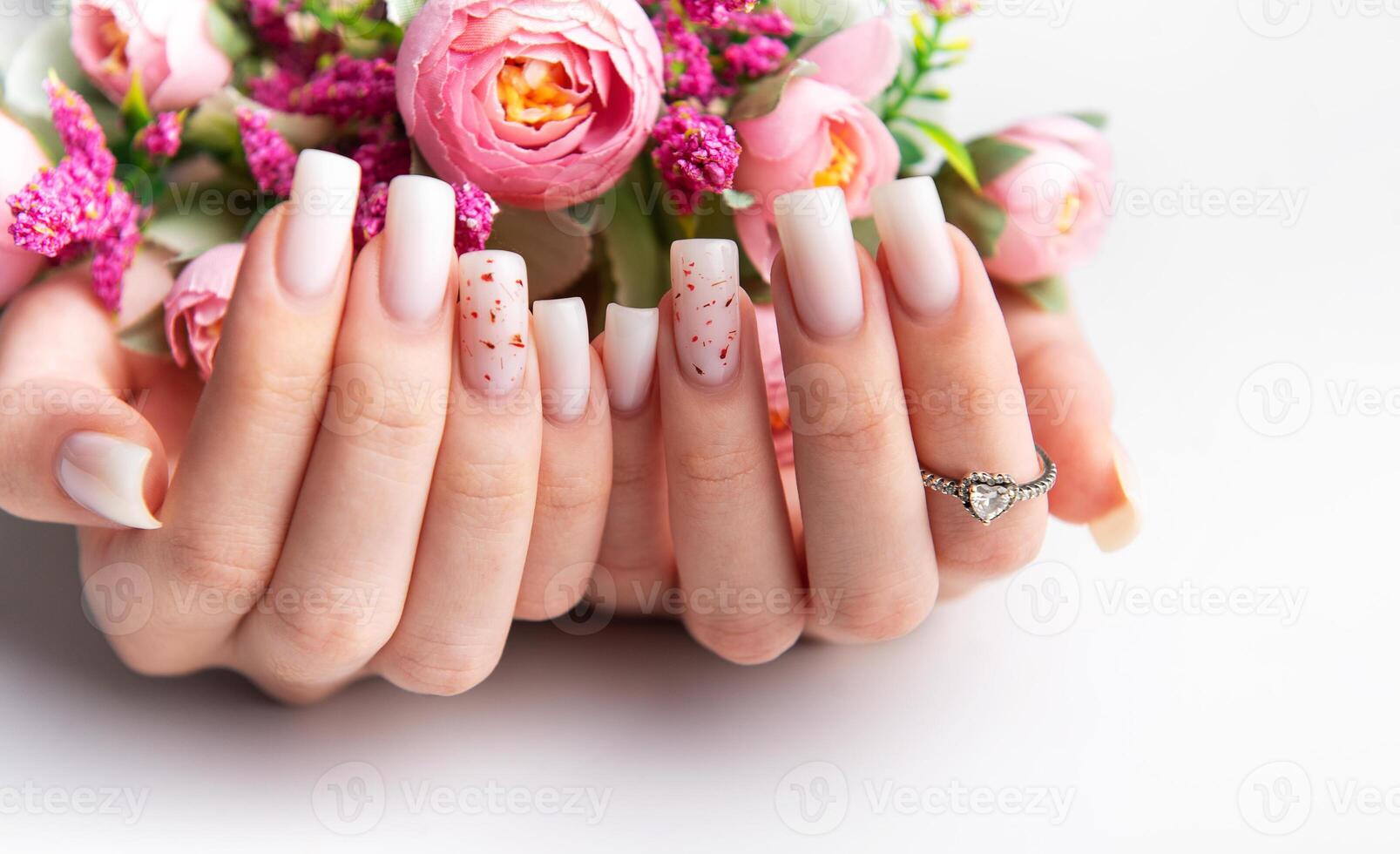 Woman showing stylish manicure holding pink flowers photo