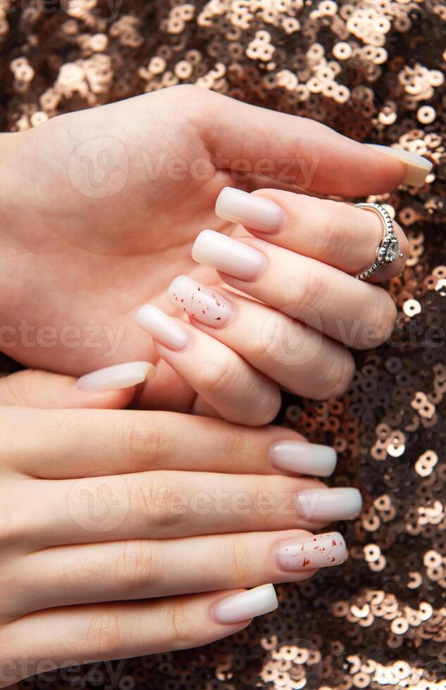 Woman showing stylish nails with red glitter on sequins background photo