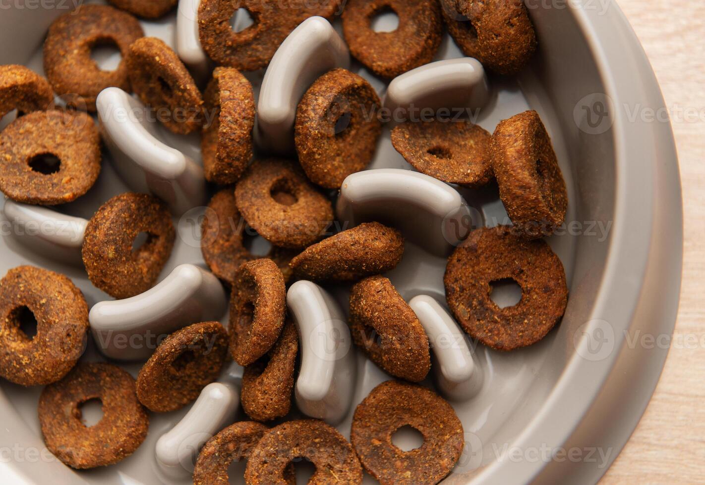 Dry dog food in slow feeder bowl preventing gulping and improving digestion photo