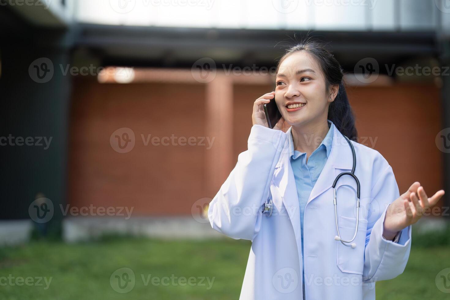 Nurse engaged in a phone conversation, smiling while standing in a contemporary healthcare environment photo