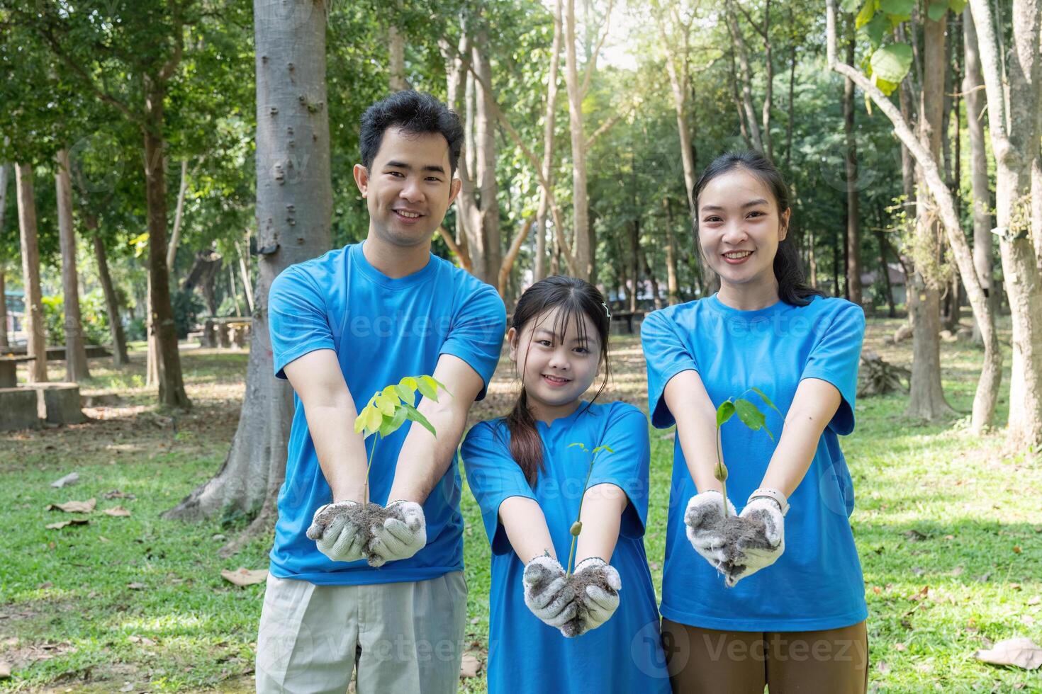 Family volunteers planting trees for a greener environment and saving the world photo