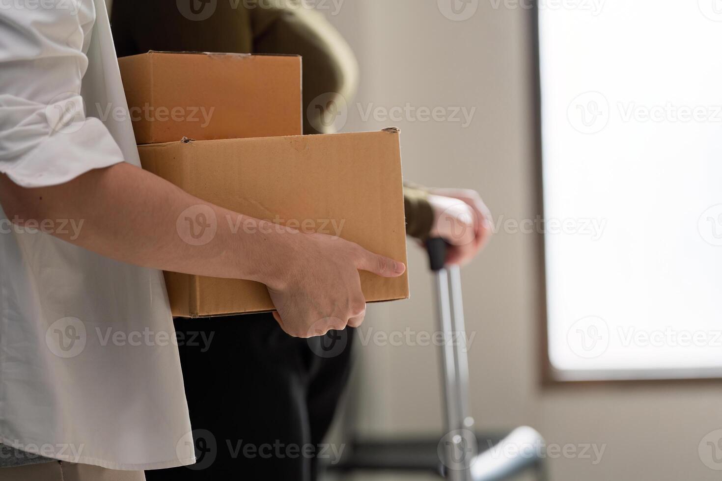 Couple relocating together, carrying moving boxes while preparing to settle into their new home photo
