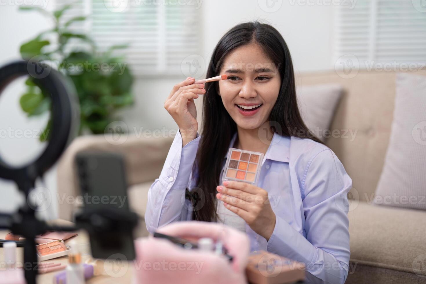 Beauty broker applying eyeshadow with a brush while showcasing her palette in a live broadcast photo