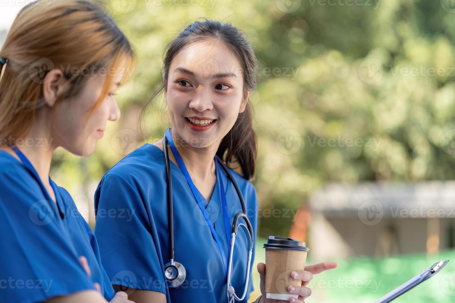 Doctors enjoying a break, conversing with coffee and a clipboard. photo