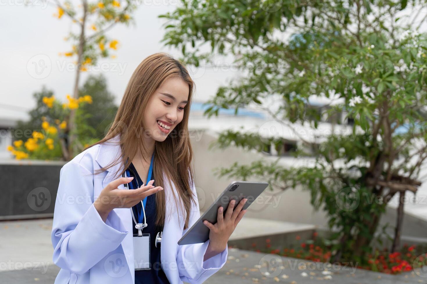 Engaged doctor smiling while using a tablet for patient communication photo