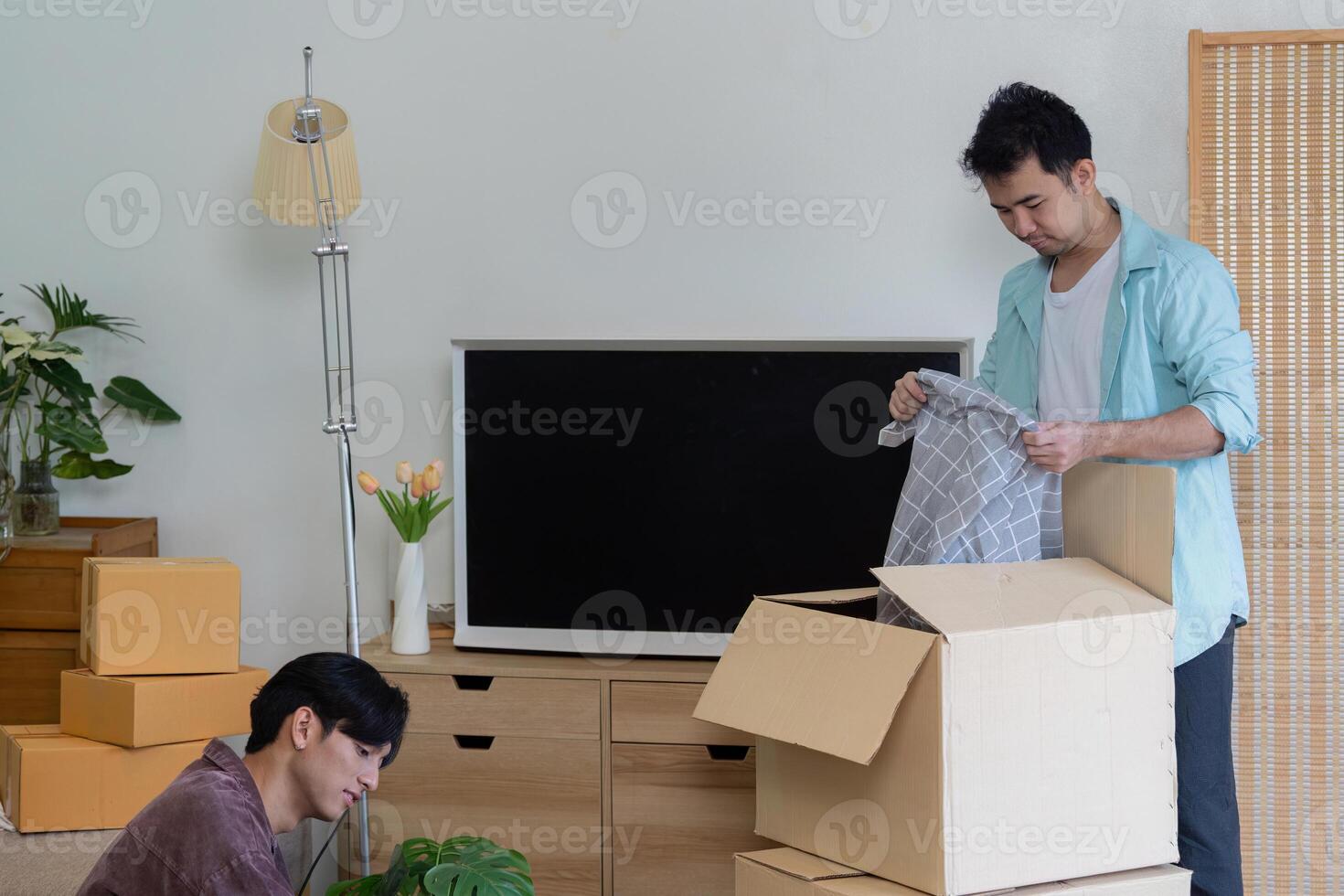 LGBT couple organizing their new home while unpacking boxes together photo