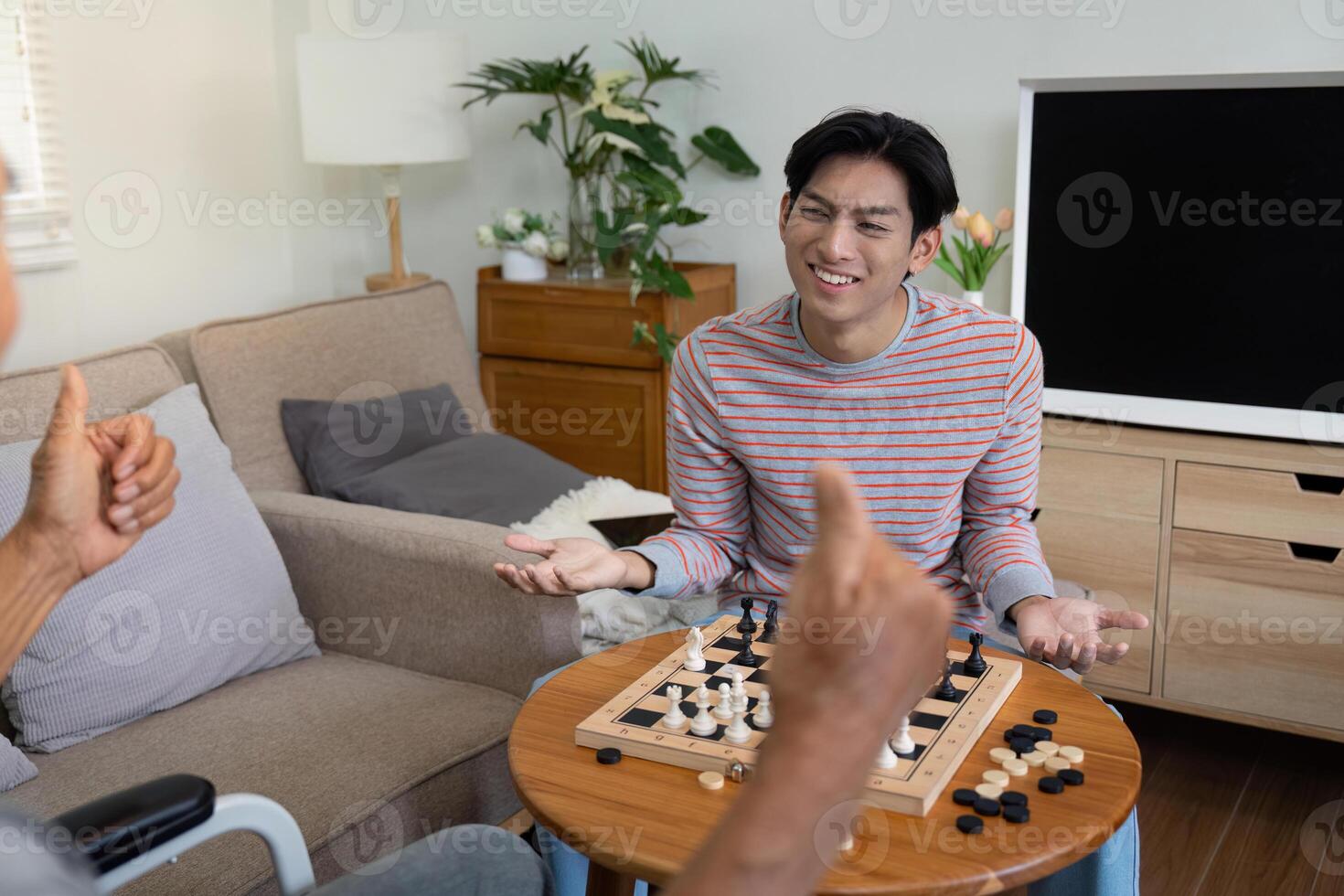 Son expressing surprise during a chess game with his father at home. photo