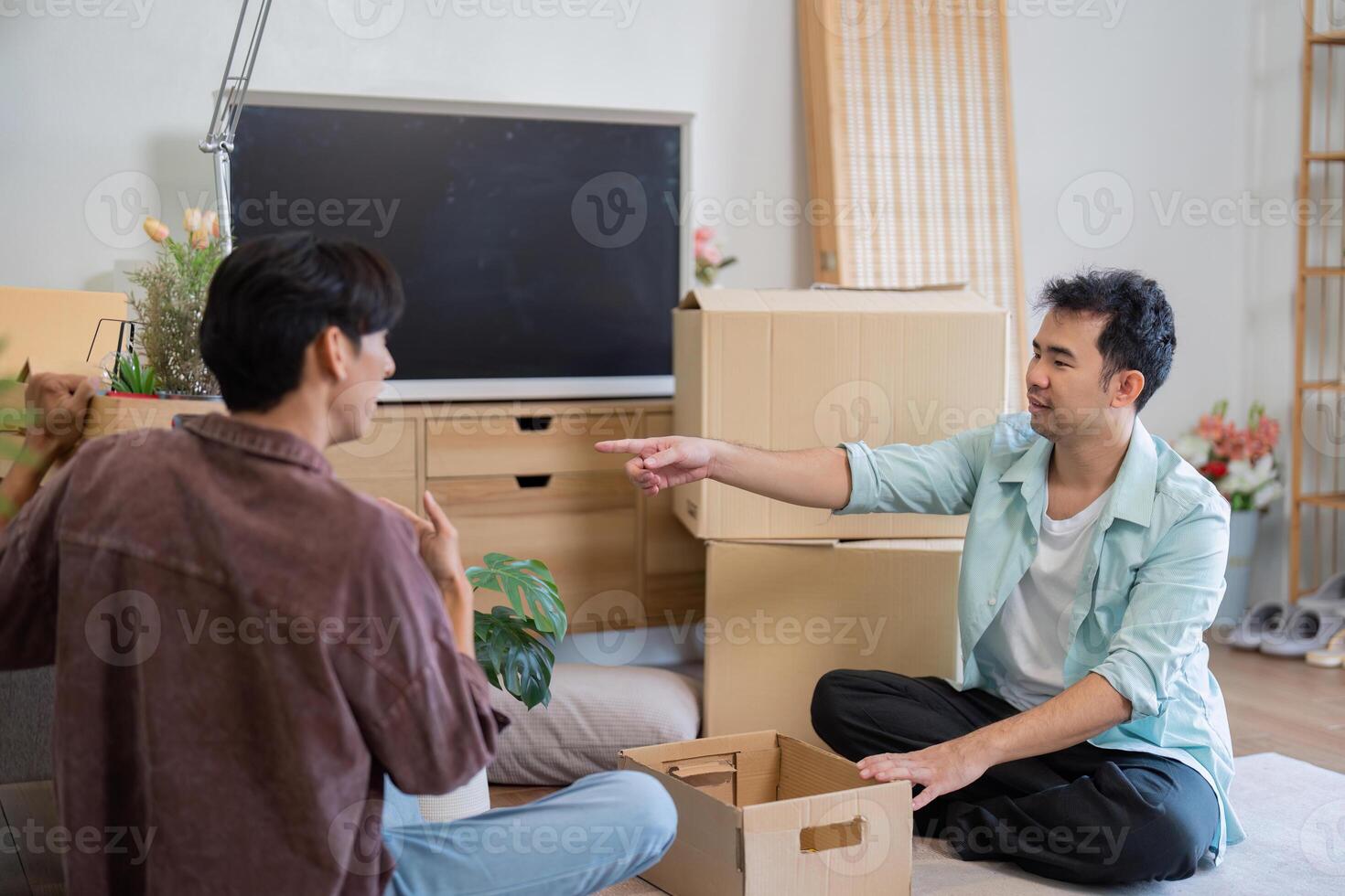 LGBT couple engaging in conversation while unpacking boxes in their new home photo