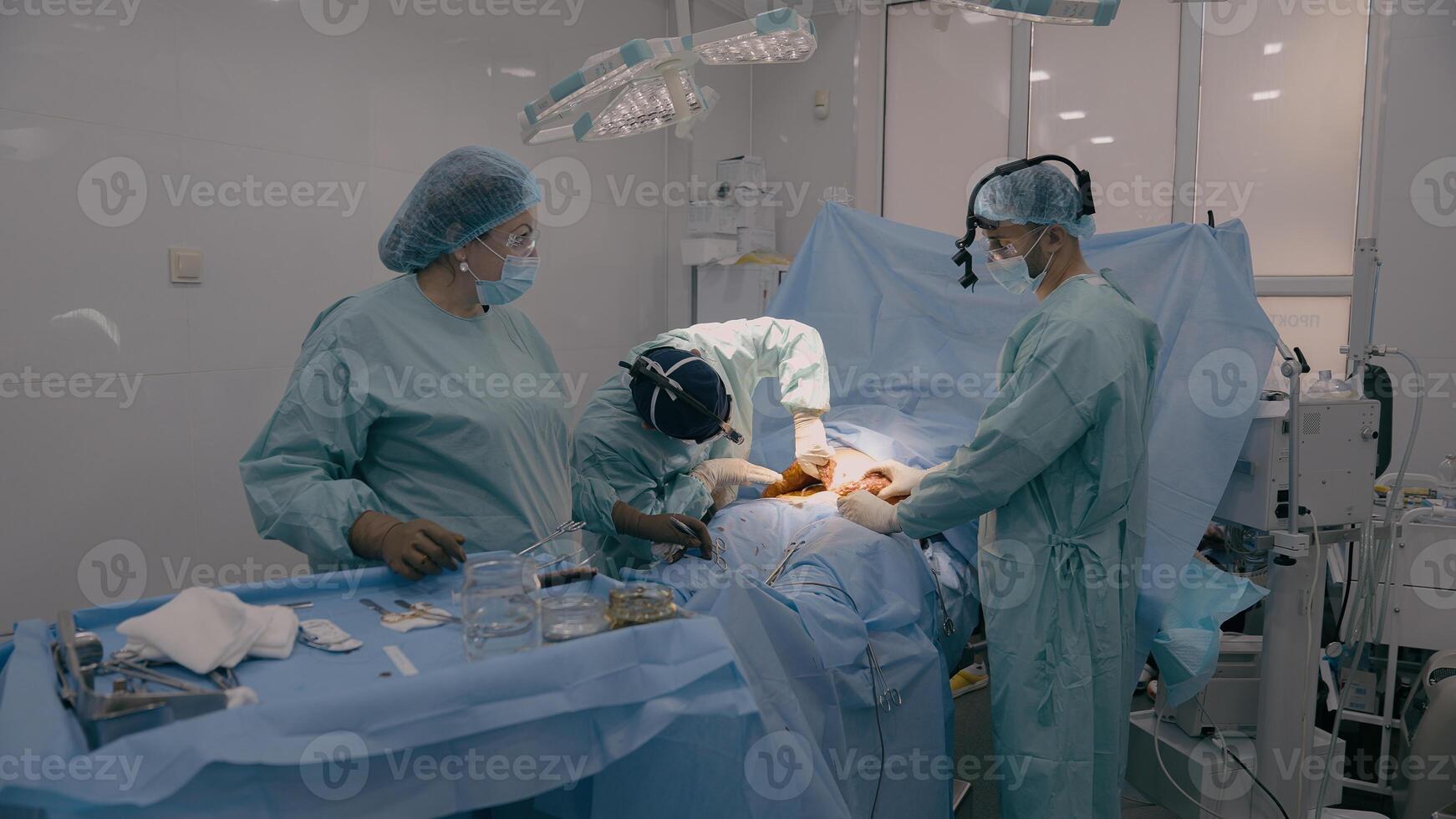 Medical team men doctors physicians surgeons nurse processing surgical operation in hospital clinic emergency medicine heart stomach surgery cut out appendicitis cancer tumor disease health patient photo
