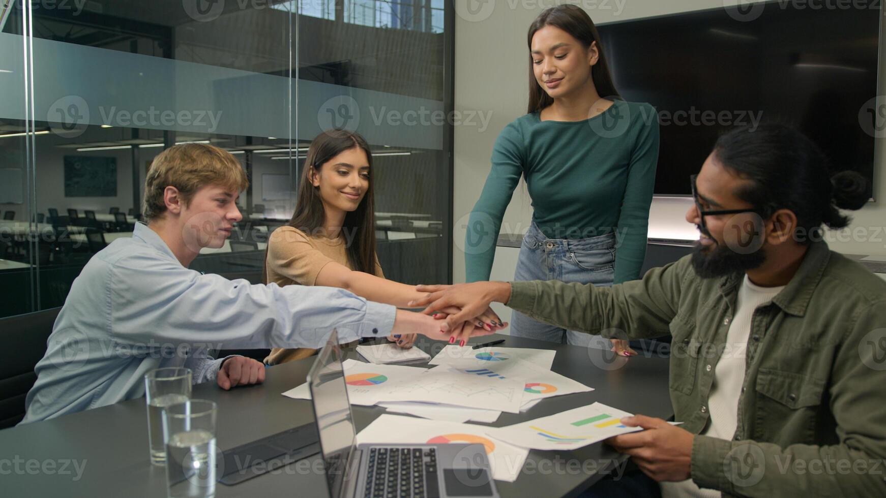 Multiracial group company business coworkers men women girls guys male female stacking hands in pile team gesture unity put arms together partners businessmen businesswomen motivation work in office photo