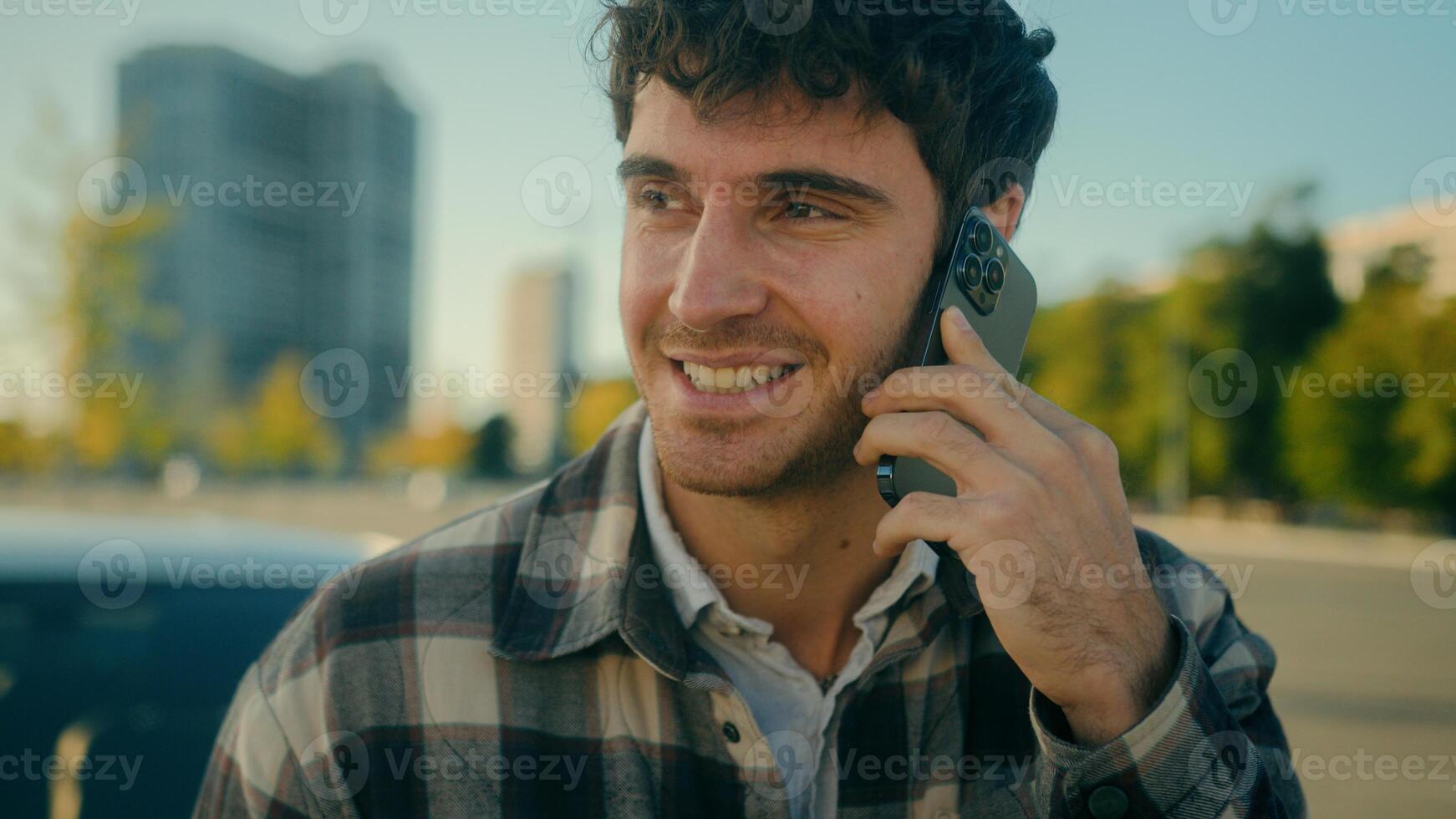 Smiling guy handsome 30s Caucasian man driver talk mobile phone with auto car background on parking happy male successful businessman calling smartphone friendly conversation in city urban lifestyle photo
