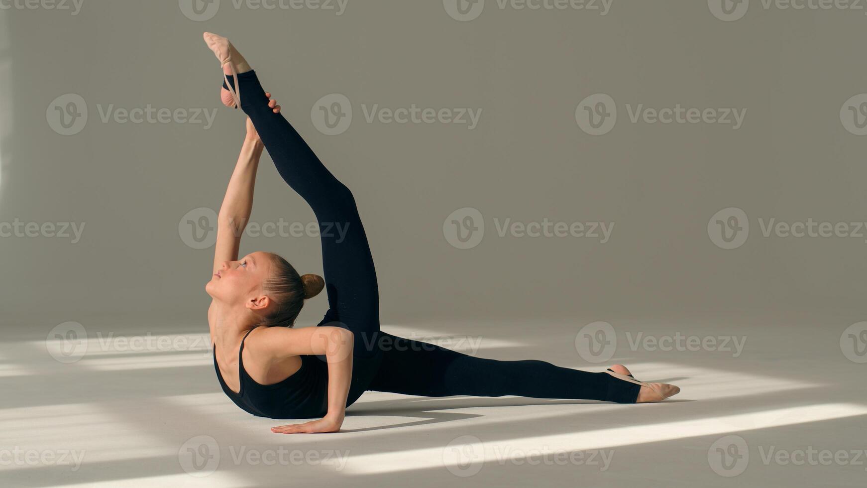 Caucasian sport girl little kid child daughter schoolgirl gymnast ballerina dancer flexible acrobat back bend exercise female teen athlete stretching body indoors gymnastics ballet studio dance school photo