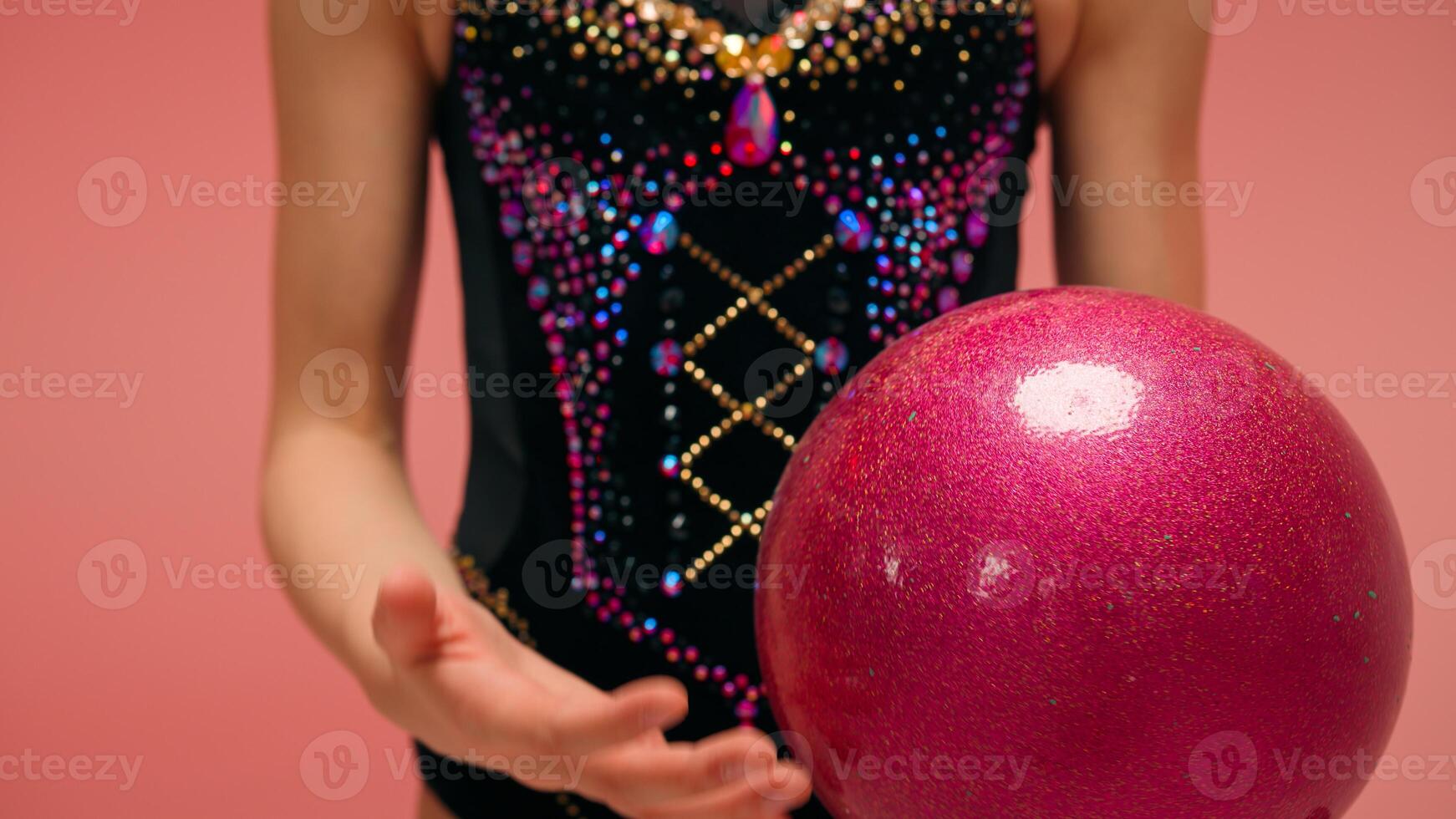 Cropped shot female hands rotating spinning gymnastic ball unrecognizable dancer ballerina artistic gymnast little girl child kid in leotard preparing for rhythmic gymnastics sport acrobatic exercise photo