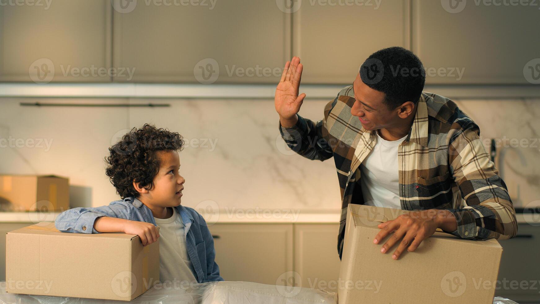 African American ethnic happy family father son moving in new own apartment buy rent house happy male home owners dad little kid boy child giving high five hand gesture teamwork celebrate relocation photo