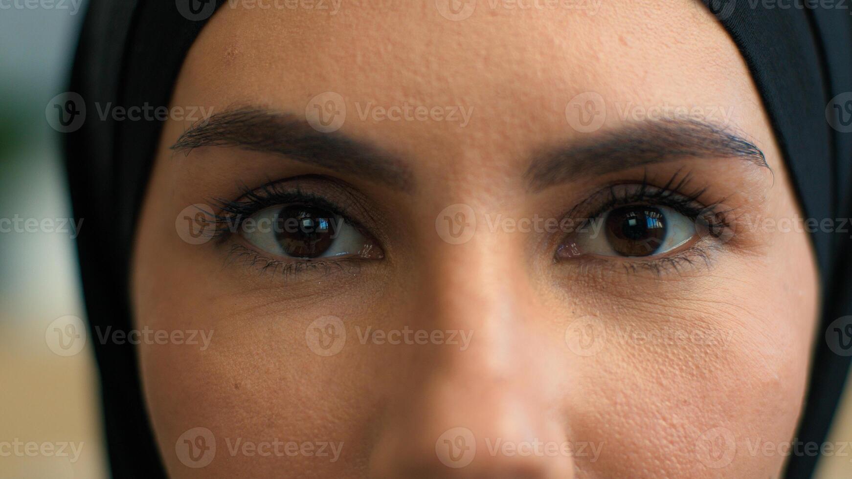 Close up macro extreme eyes woman Muslim islamic female in hijab arabic girl eye opening stare looking camera face details eyesight vision iris dark eyeball open eyelashes beauty makeup look mystery photo