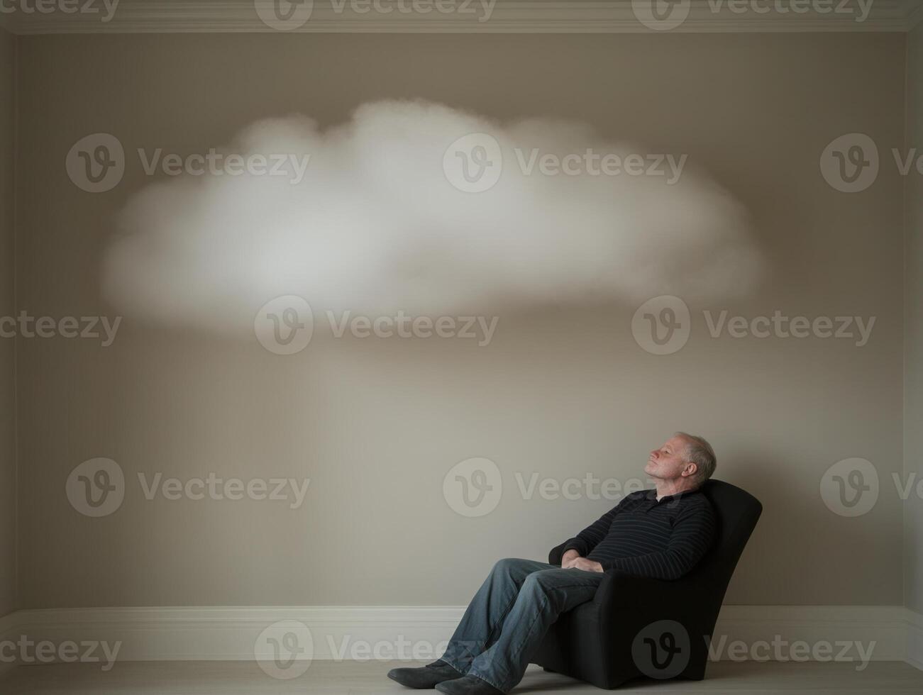 Senior man relaxing and daydreaming under a cloud indoors photo