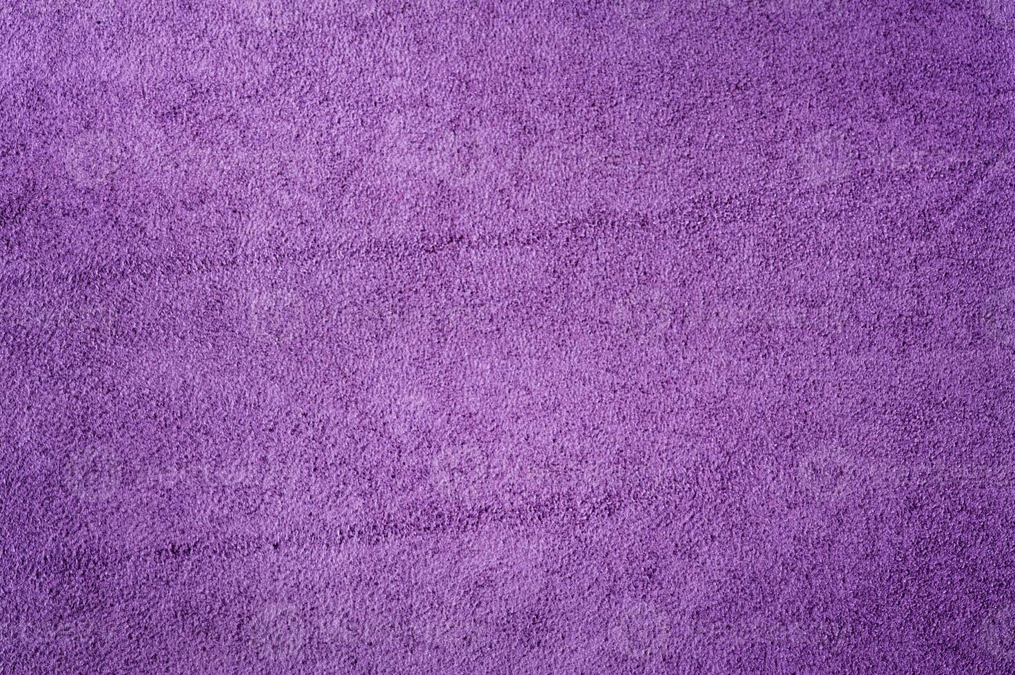 Purple suede as a background. Macro photo of the texture of natural dyed purple suede leather