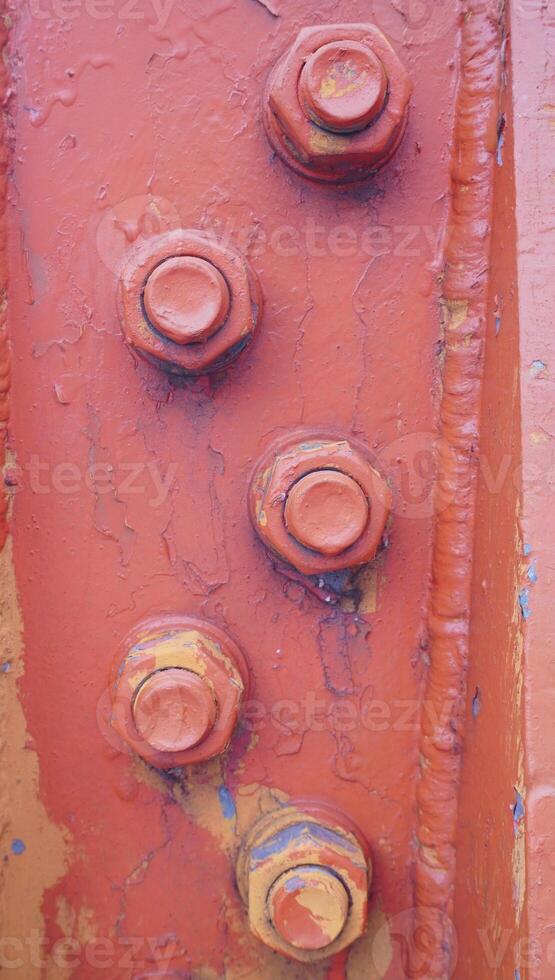 a close up of a rusty metal structure with four bolts photo