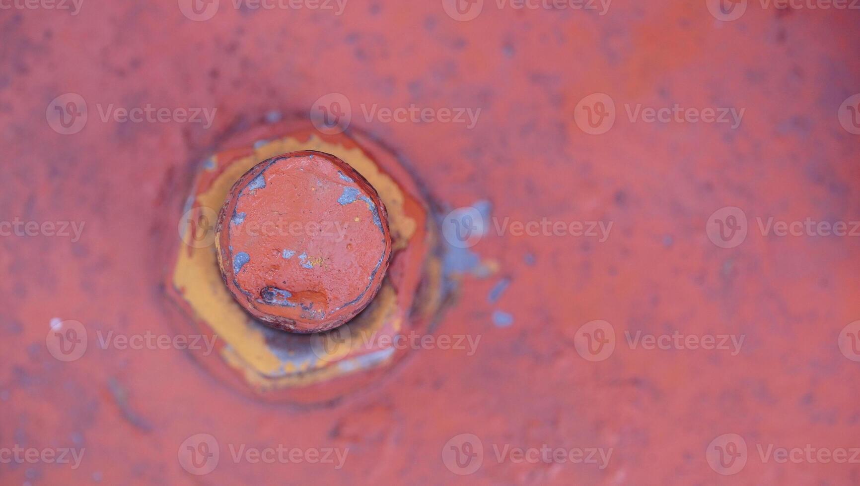 a close up of a rusty red bolt on a metal object photo