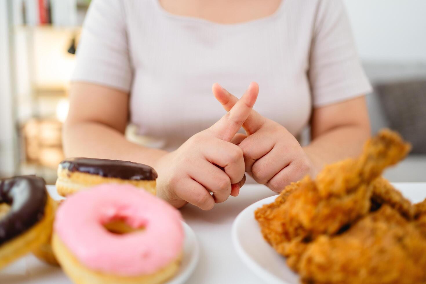 A woman refuses to eat fast food, fried chicken and donuts on her plate to lose weight and stay healthy photo