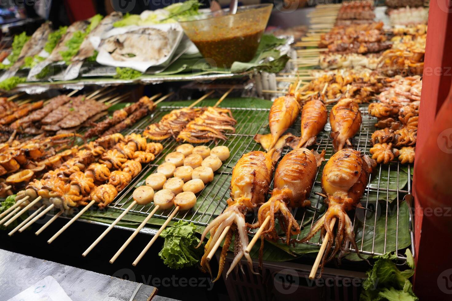 Seafood skewers at night Market or bazaar, grilled baby octopus, squids and scallops grill photo