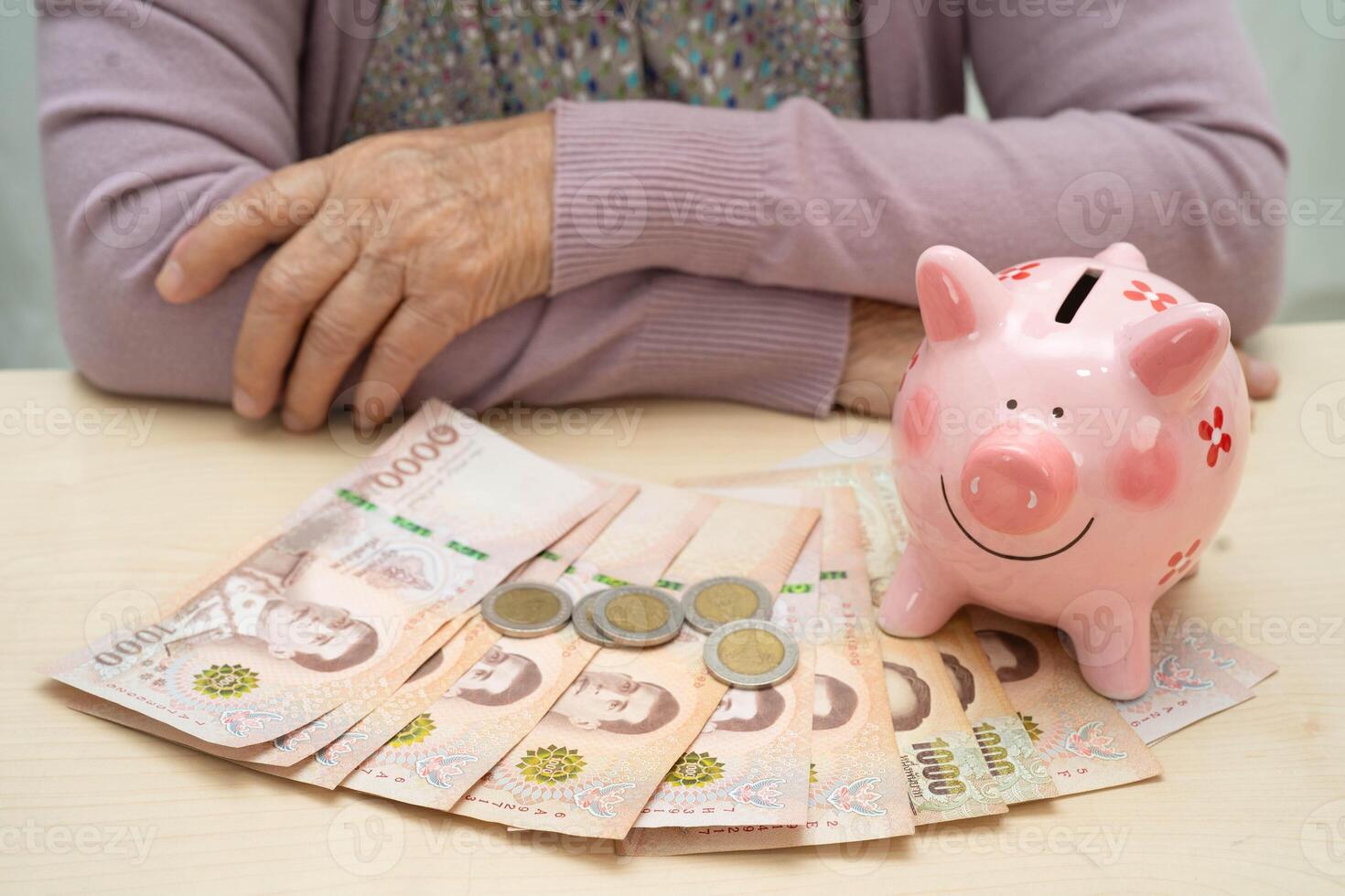 Retired elderly woman counting coins money with piggy bank and worry about monthly expenses and treatment photo