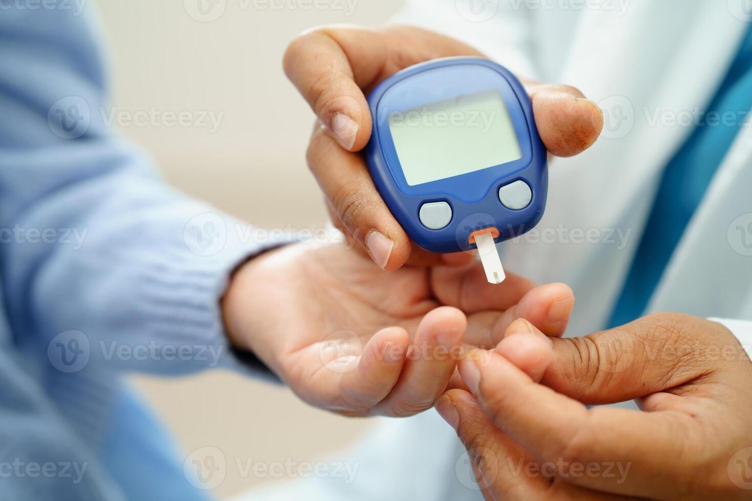 Asian doctor using digital glucose meter for check sample blood sugar level to photo