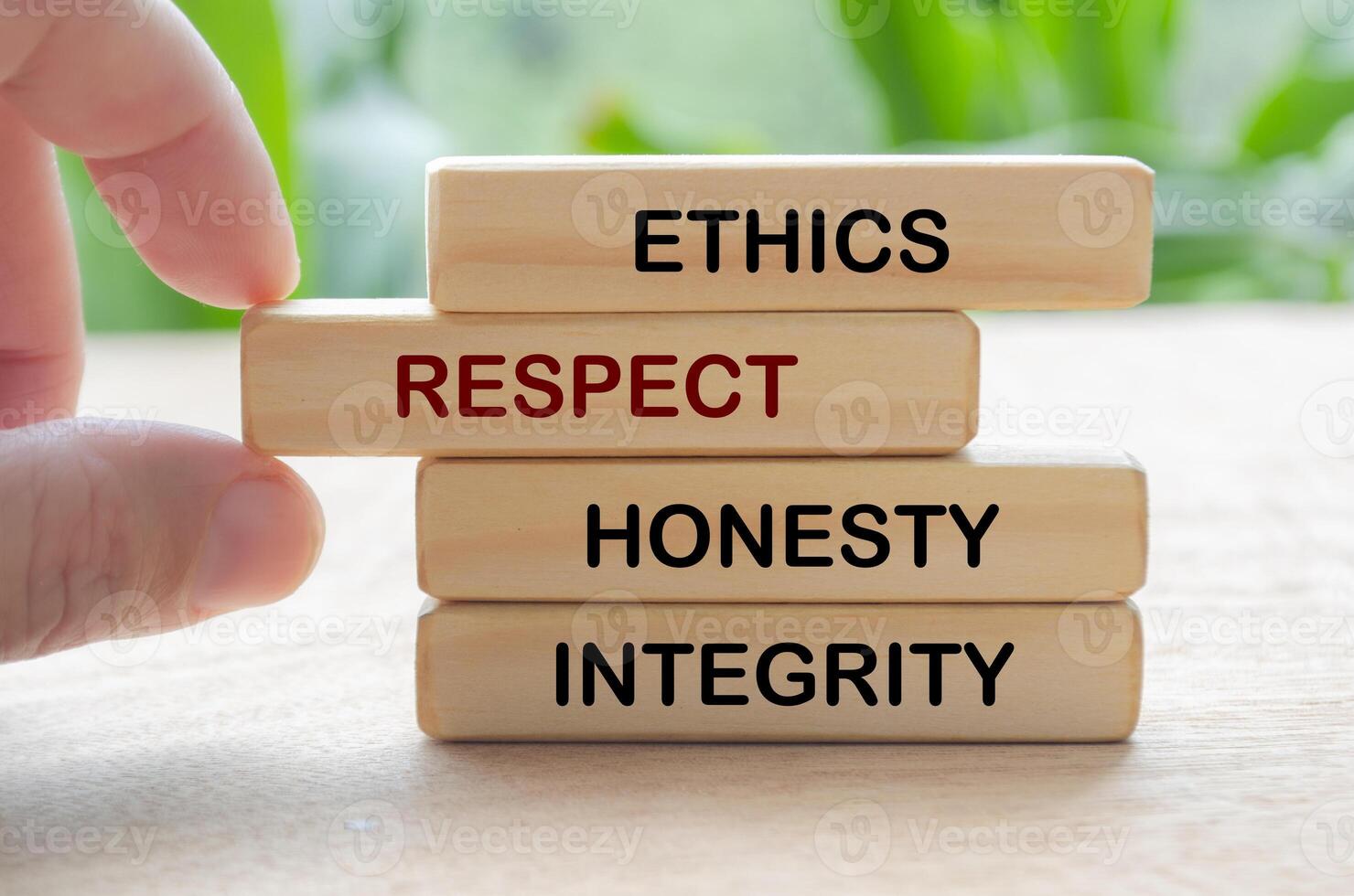 Ethics, respect, honesty and integrity text on wooden blocks with blurred nature background photo