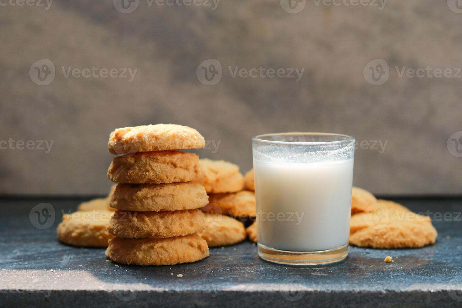Milk in glass and cookies a black table, closeup of photo