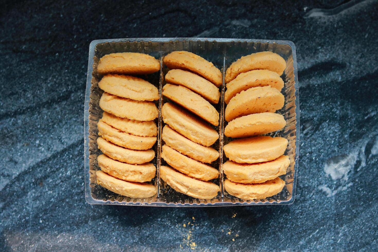 Cookies in a plastic box on a dark background, top view photo