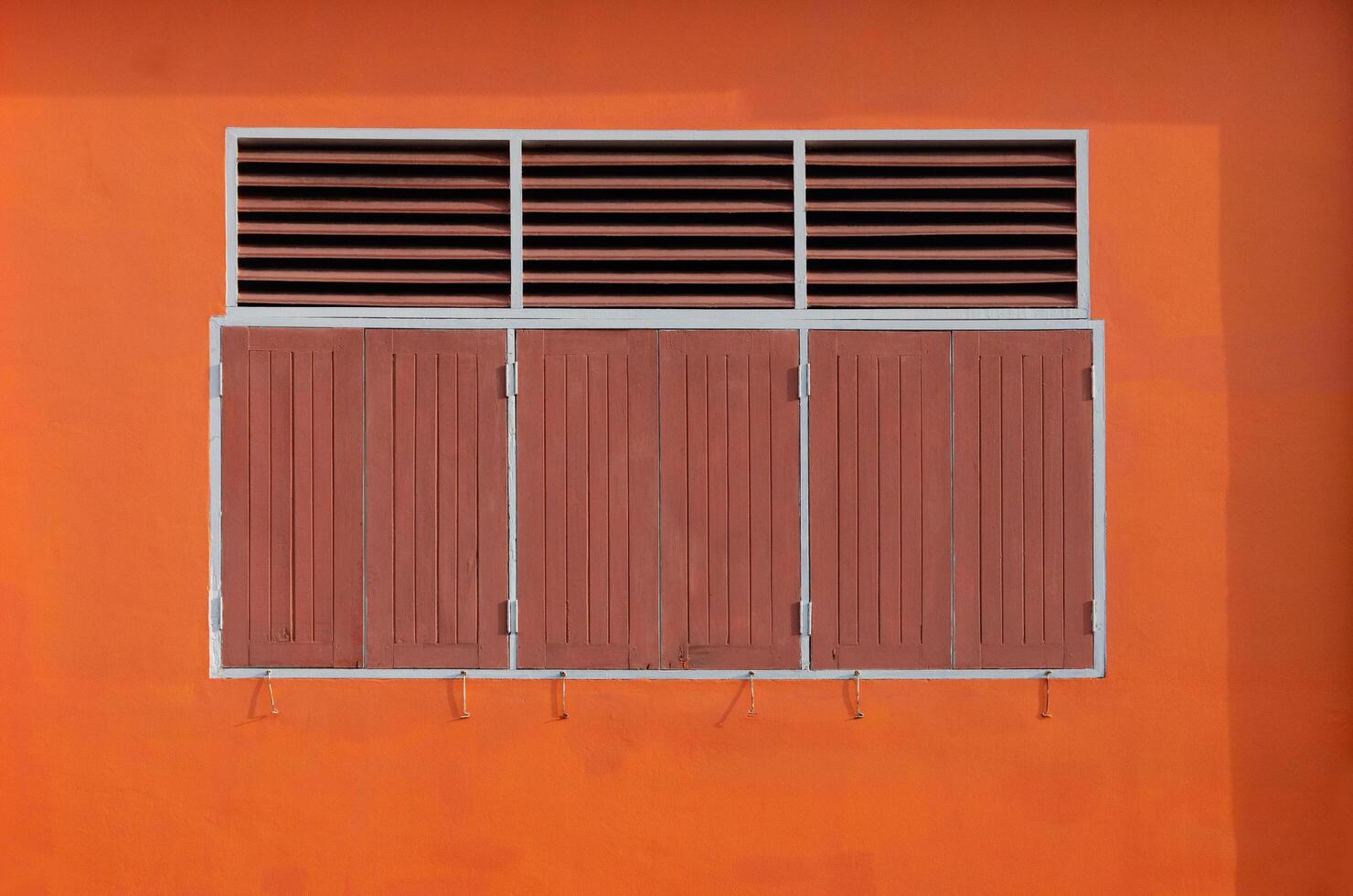 Vintage Wooden Window with orange concrete wall, Background texture aged old orange concrete wall and wooden windows photo