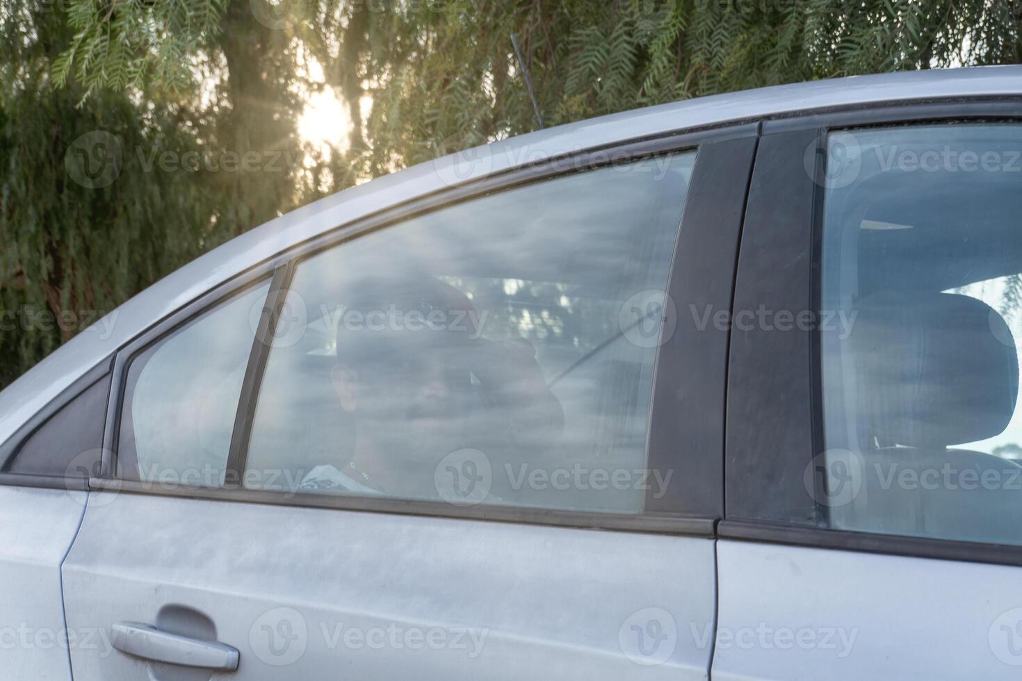 Car parked under trees with sunlight shining in the late afternoon photo