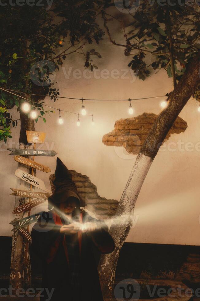 Man dressed as a wizard inspired by a magic-themed book series performs a spell outdoors photo