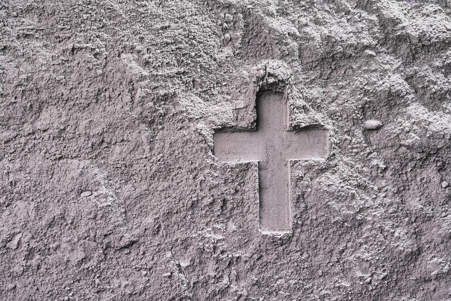 Cross imprint in gray ash surface. Ash Wednesday photo