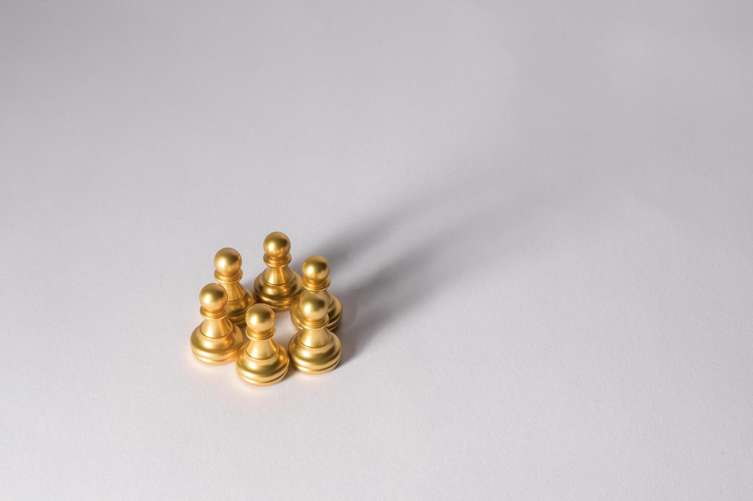 Golden Pawns Arranged in a Strategic Formation on a Light Background Showcasing Potential Moves photo