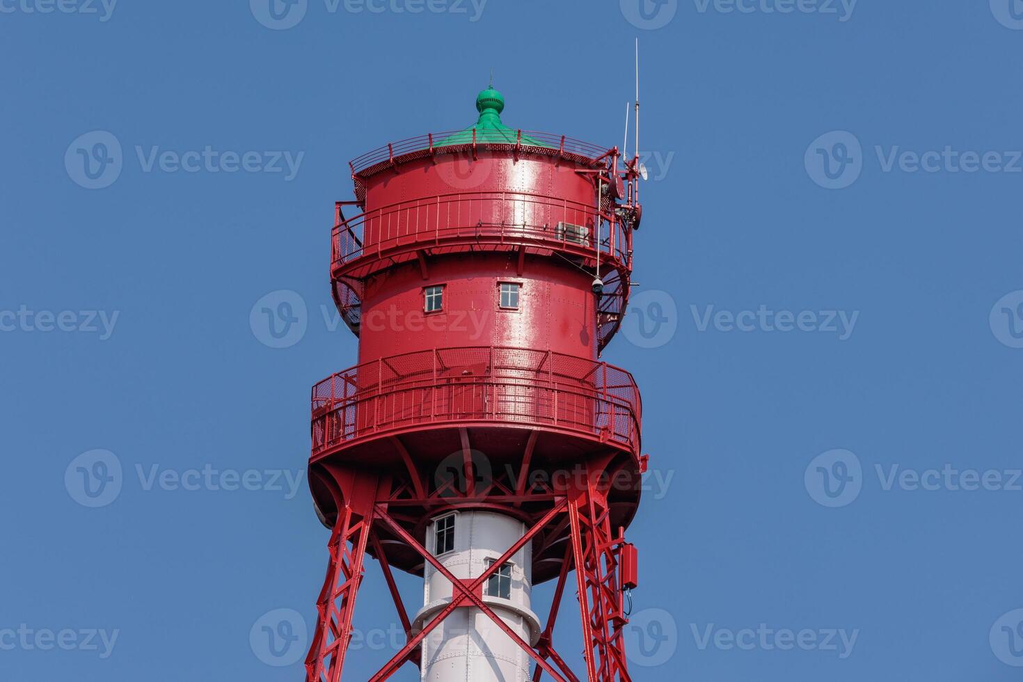 A red tower with a green light on top photo