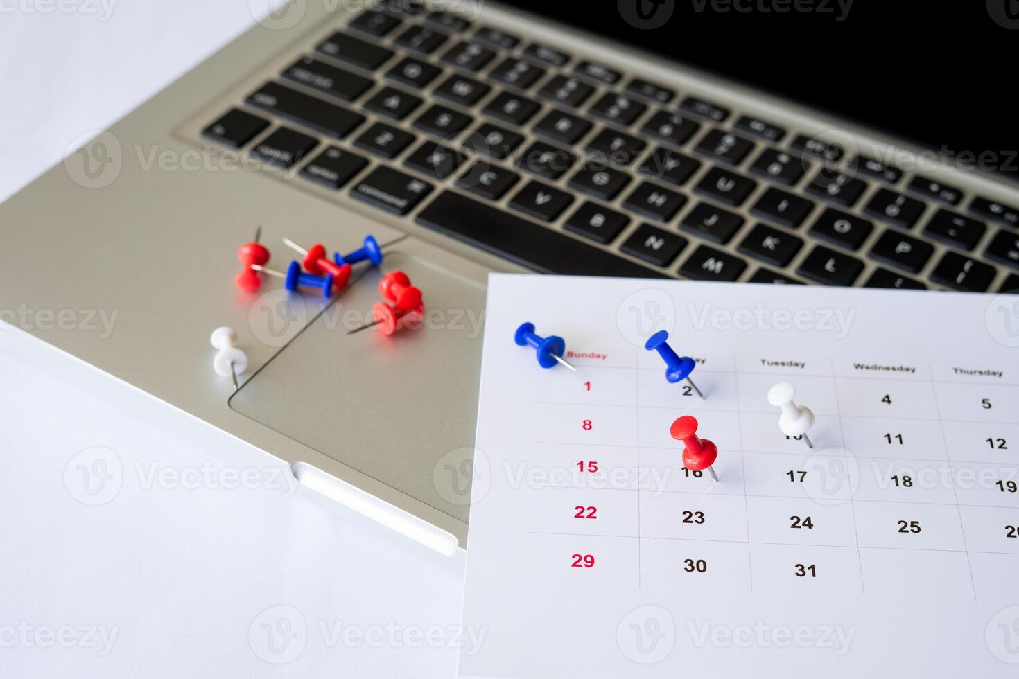 push pin with calendar on laptop photo