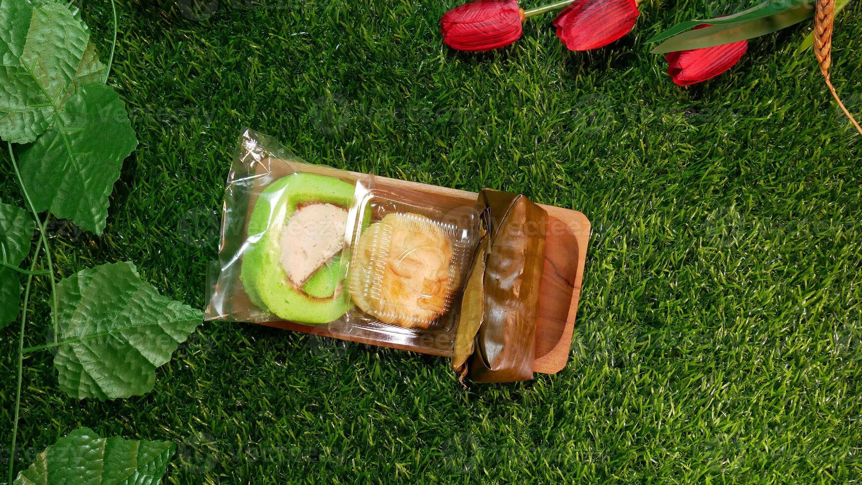 Top View Traditional Indonesian snacks, various types of sweet and delicious snacks such as cream puffs, roll cakes, and lemper which are commonly known as kue with Natural Decorative Touches photo