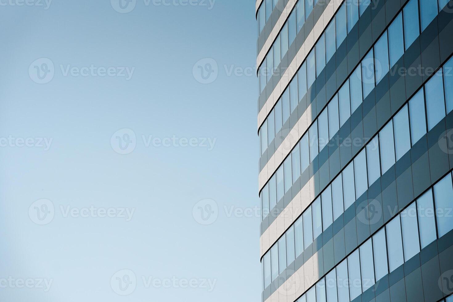 A plane flying over a building with a blue sky photo
