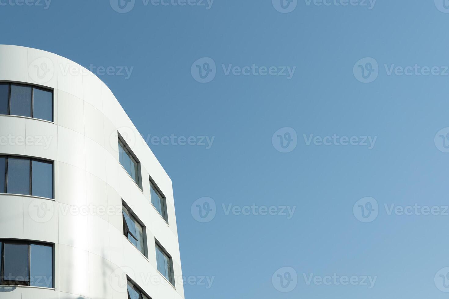A white building with windows and a blue sky photo
