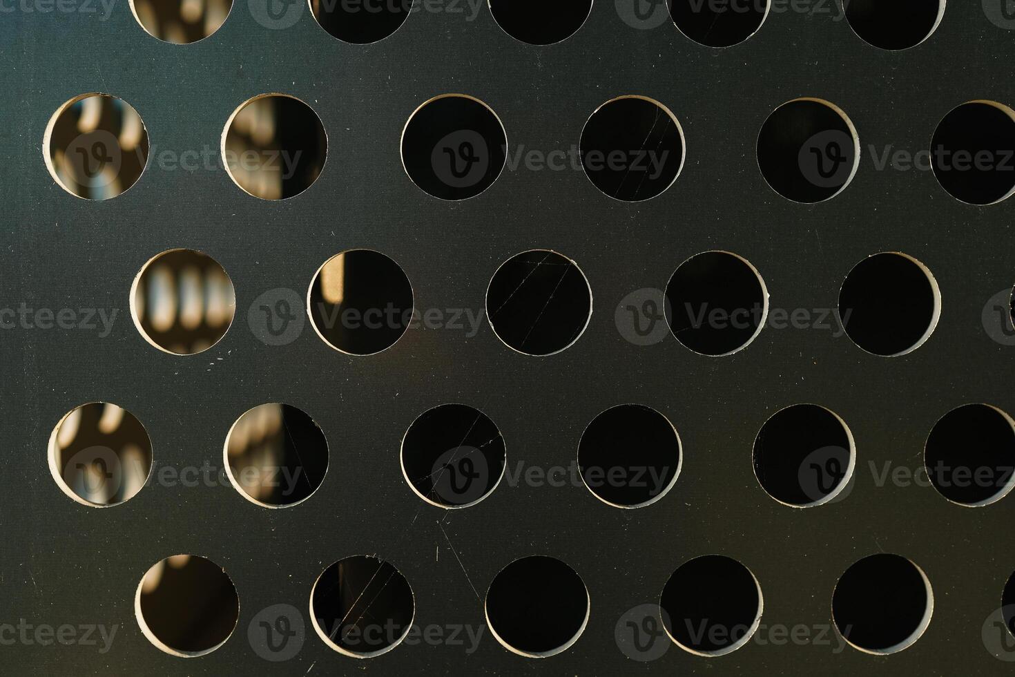 Abstract shiny metal background in silver color with round holes texture. Perforated metal background photo