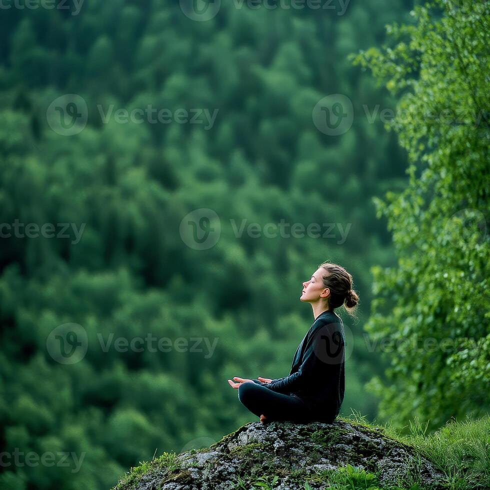 A woman meditating in the forest photo