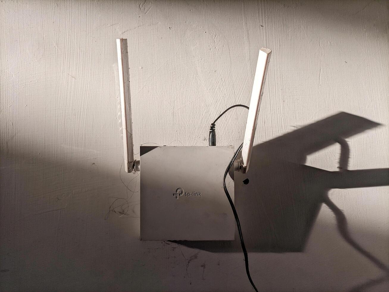 Medan, Indonesia 24 January 2025 - Internet router hanging on the wall, Wi-Fi modem at home and in the office, wireless network service, connection setup. photo