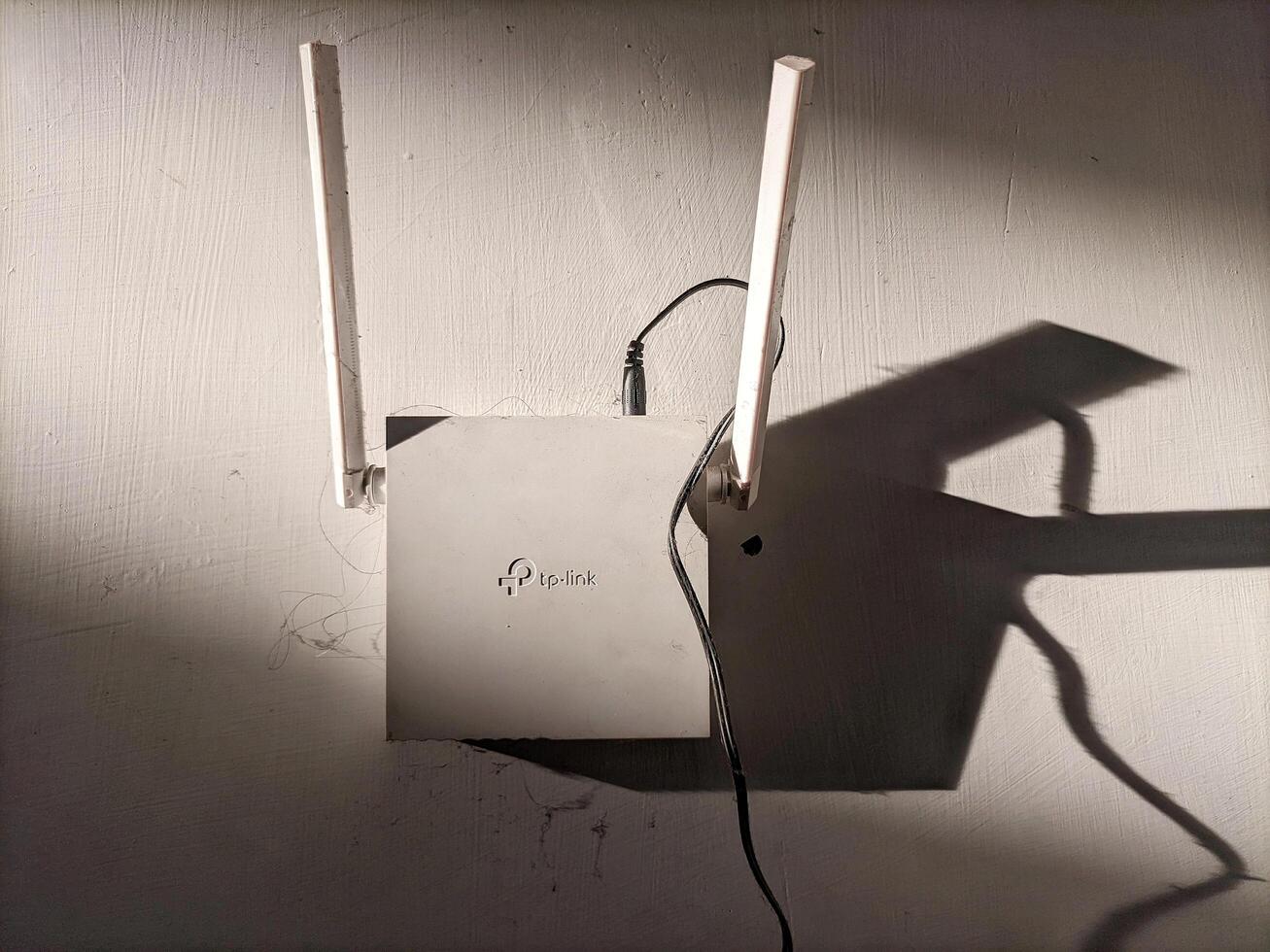 Medan, Indonesia 24 January 2025 - Internet router hanging on the wall, Wi-Fi modem at home and in the office, wireless network service. photo