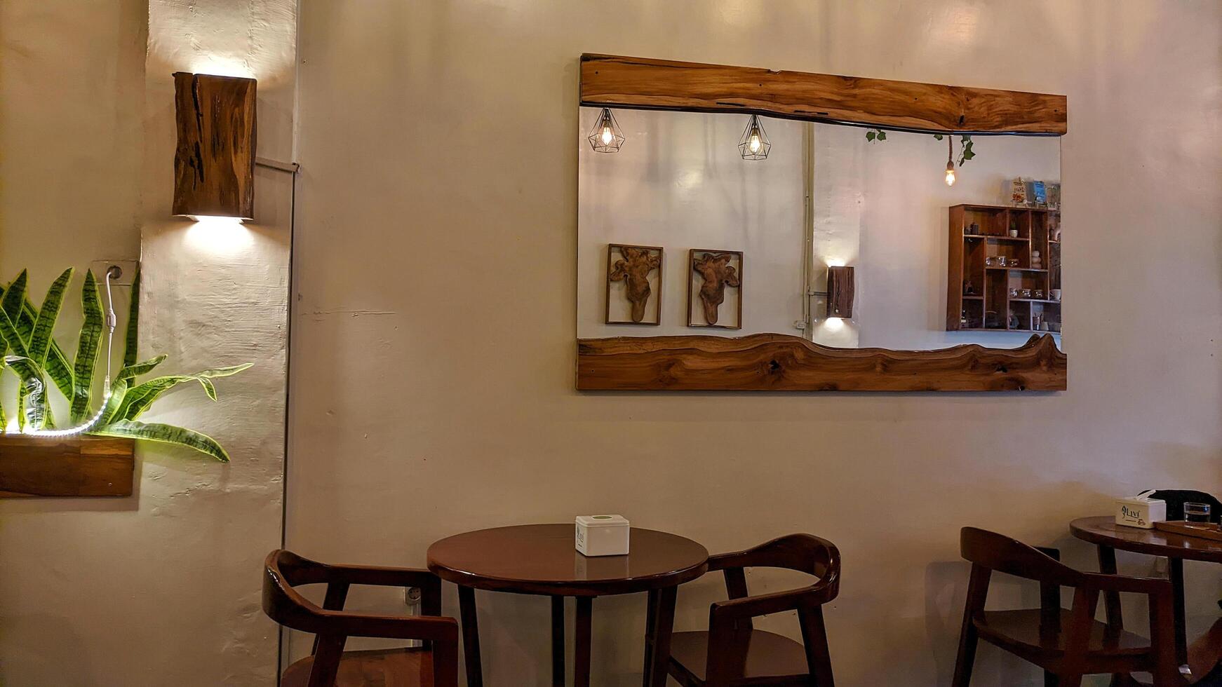 Medan, Indonesia January 22 2025 - Design Interior of a cafe or restaurant, wooden chairs and tables with a large mirror attached to the wall. photo
