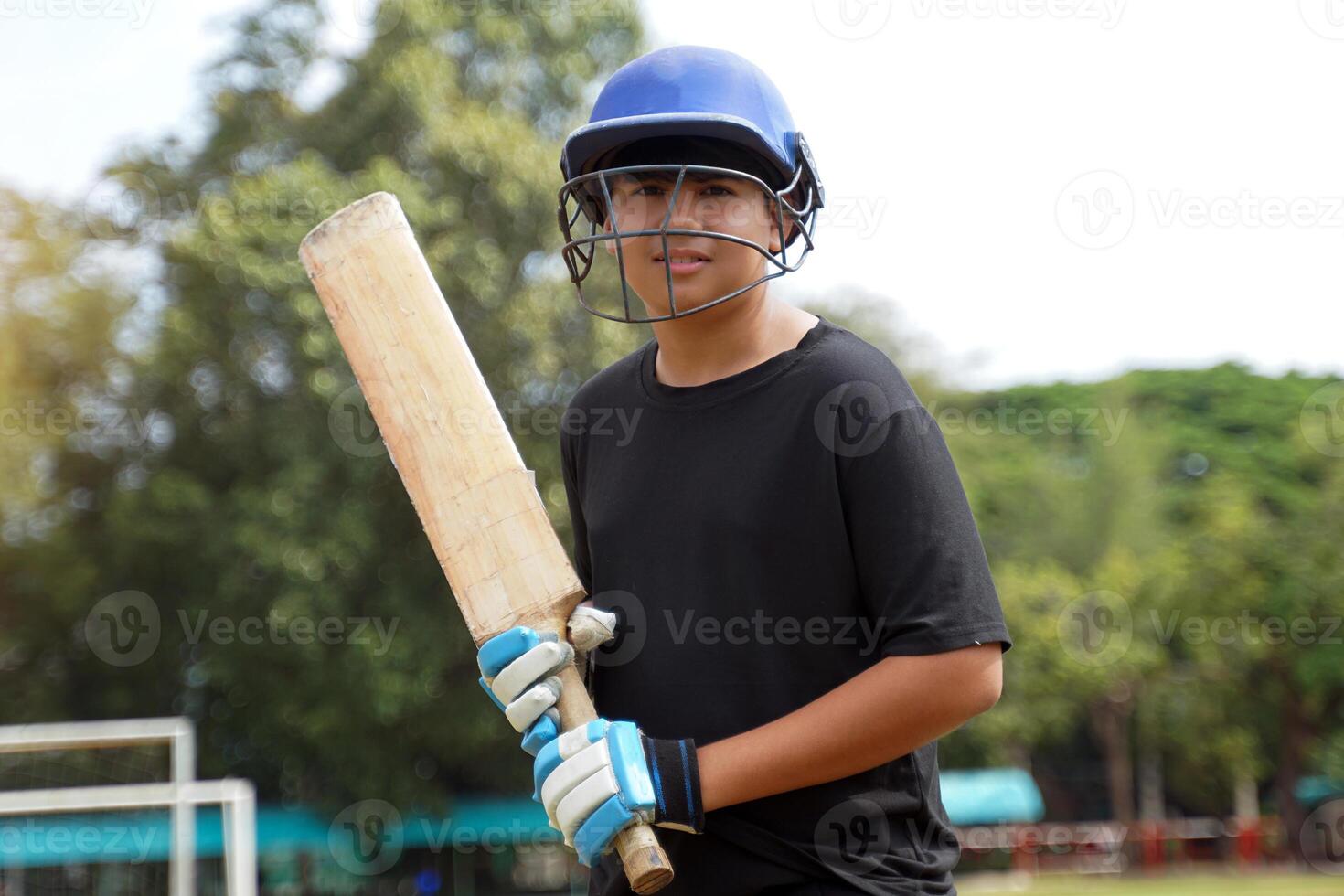 Thai cricketer holds the bat while waiting for the cricket ball. while practicing on the field. Soft and selective focus. photo