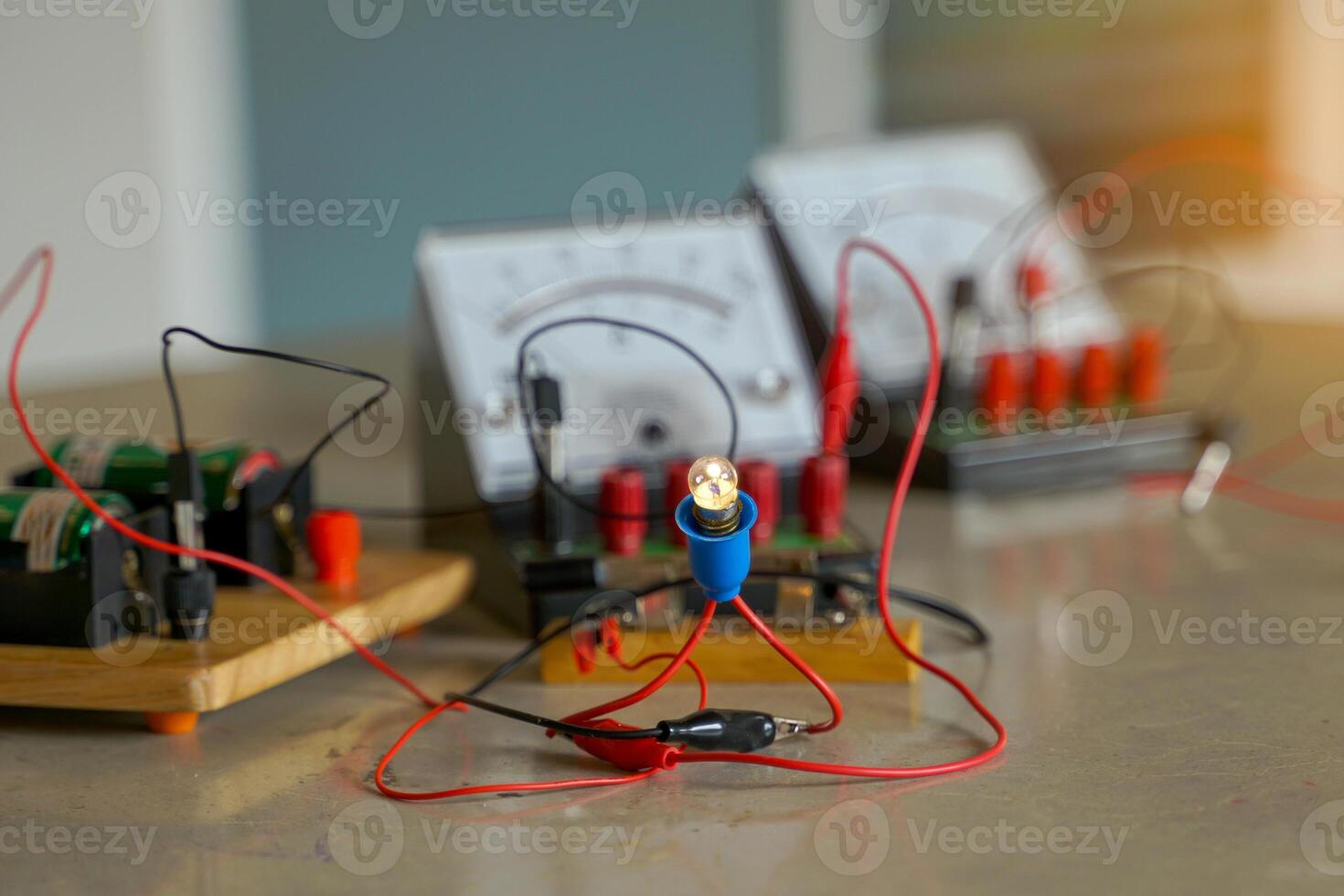 the light bulb when connected to an electrical circuit in series and a set of equipment connected to the electrical circuit, including a voltmeter, ammeter, wires and electrical bridge. photo