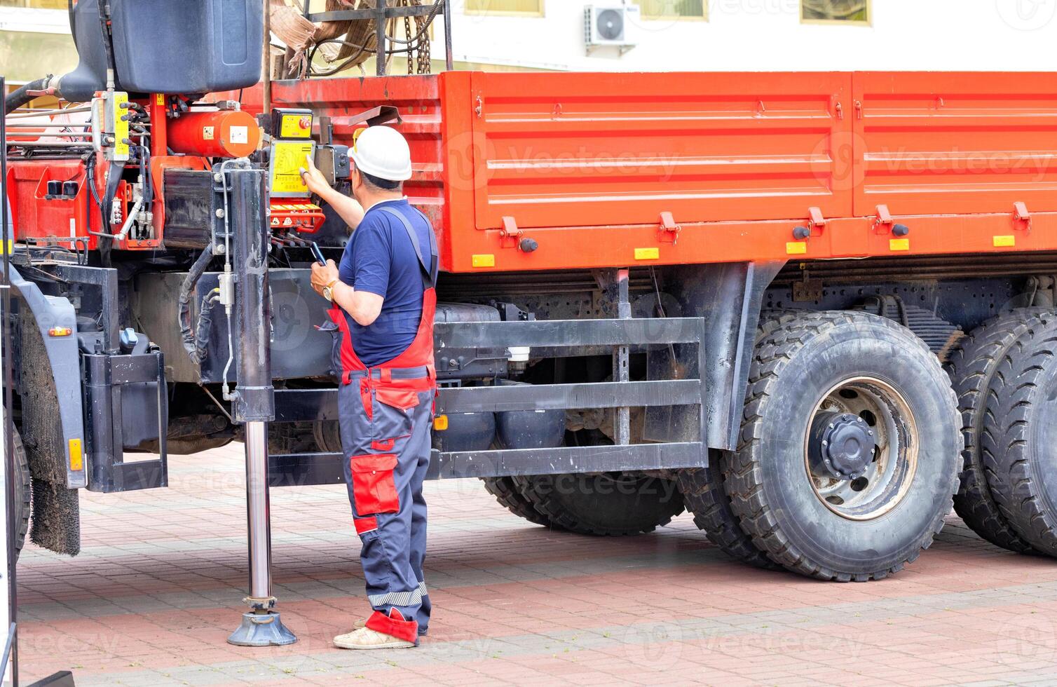 The driver of the truck mechanic with a hydraulic manipulator regulates the operation of the lifting mechanism. photo
